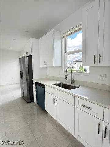 a kitchen with a sink cabinets and window