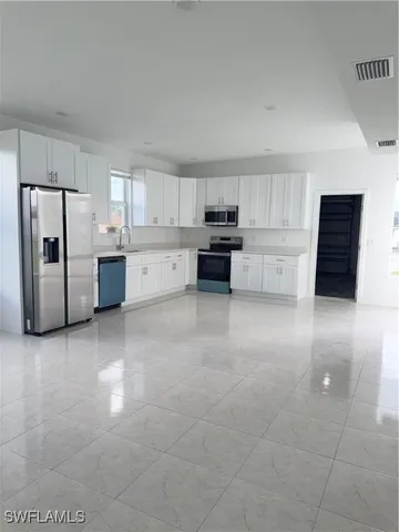 a kitchen with stainless steel appliances a refrigerator and a stove top oven