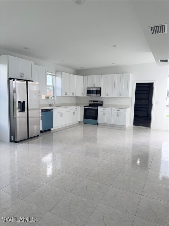1015 Jaguar Boulevard Lehigh Acres, FL 33974 - Photo 5 of 9 a kitchen with stainless steel appliances a refrigerator and a stove top oven
