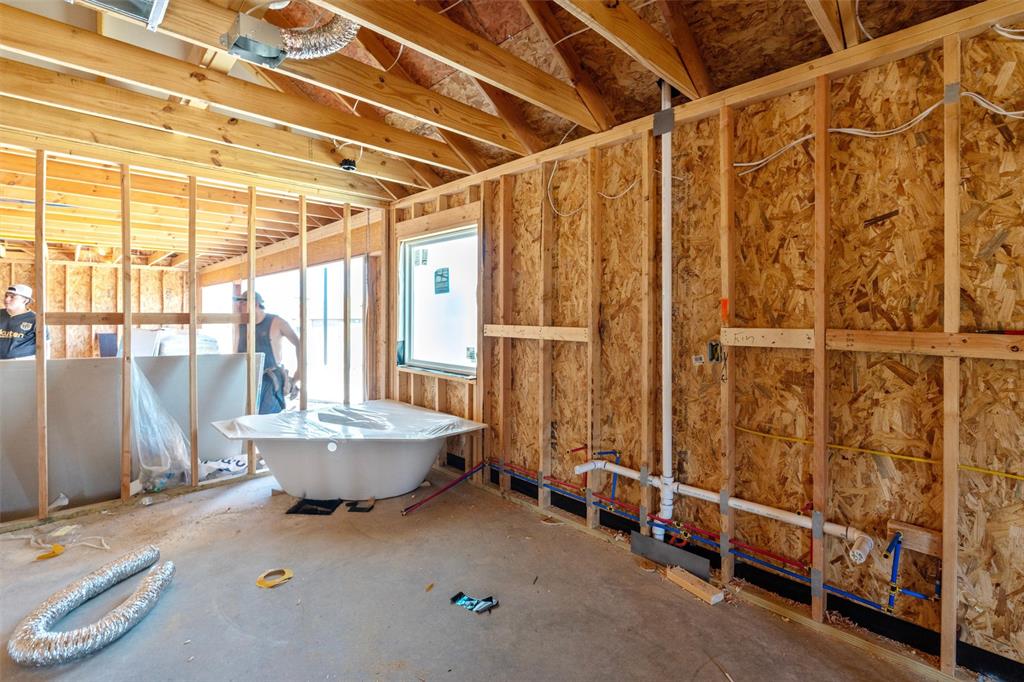 1300 Promised Land Road Hewitt, TX 76643 - Photo 17 of 21 Vaulted ceiling with exposed wood beams, framed window, freestanding bathtub, and visible plumbing rough-in