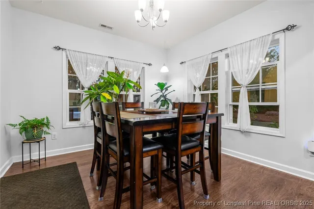 a dining room with furniture potted plants and wooden floor