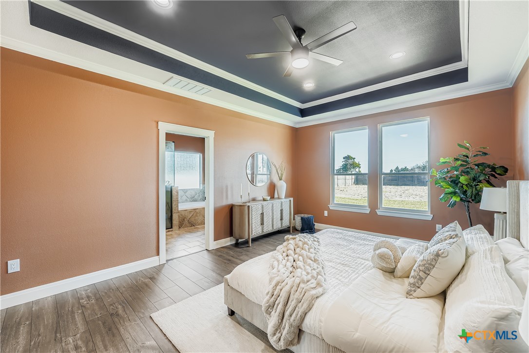 222 Arosa Drive Elgin, TX 78621 - Photo 11 of 40 a bedroom with a large bed and a chandelier