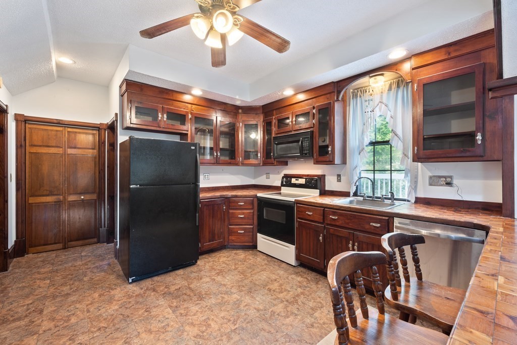 155 Worthington Road Huntington, MA 01050 - Photo 19 of 40 a kitchen with stainless steel appliances granite countertop a refrigerator a stove a sink a dining table and chairs with wooden floor
