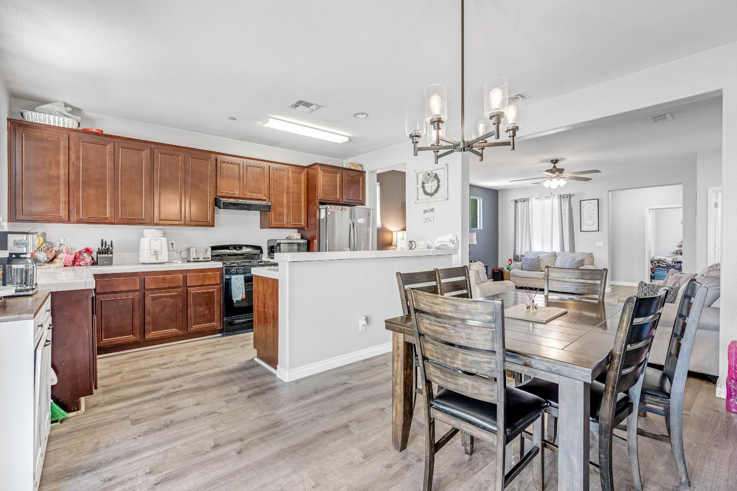 1981 Dunbar Way Dinuba, CA 93618 - Photo 5 of 12 a kitchen with granite countertop a table chairs stainless steel appliances and cabinets