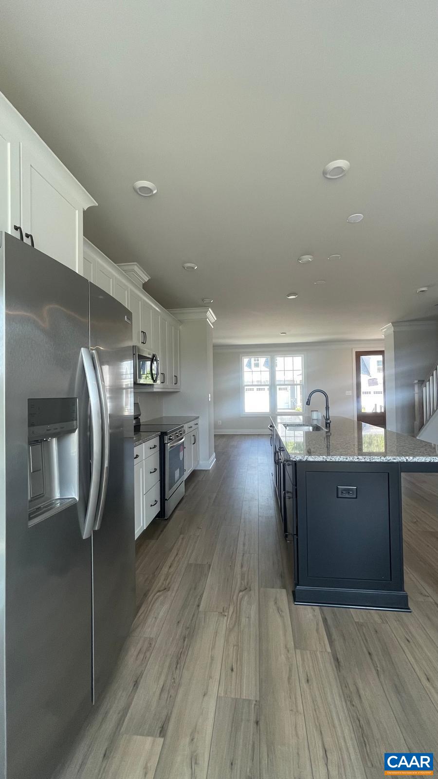 4006 Varick Street Charlottesville, VA 22901 - Photo 7 of 33 a kitchen with stainless steel appliances granite countertop a refrigerator a sink dishwasher a stove and a dining table with wooden floor