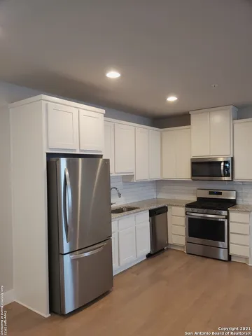 a kitchen with stainless steel appliances granite countertop a refrigerator a stove a sink and a microwave