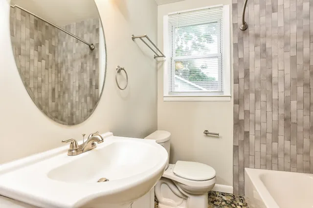 a bathroom with a sink a toilet and a mirror