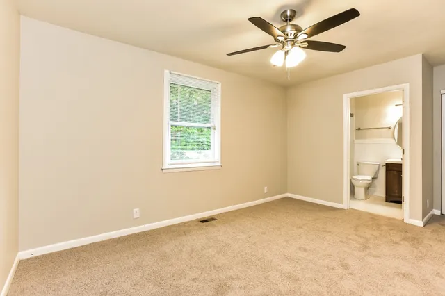 an empty room with a window and a ceiling fan