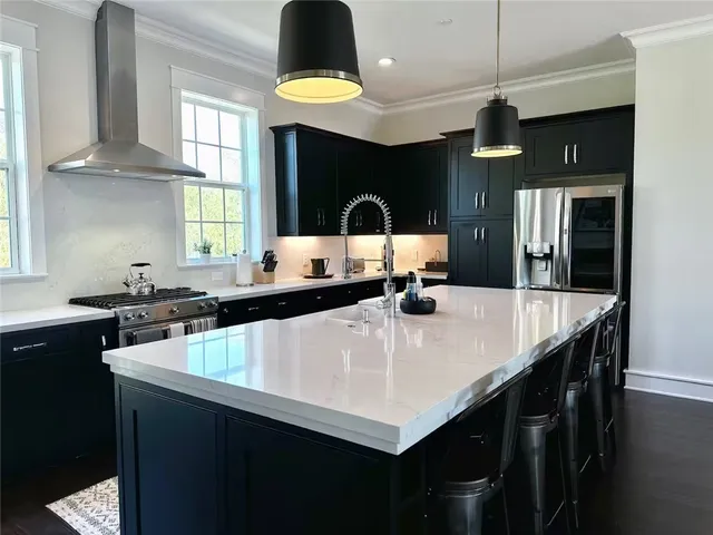 a kitchen with a table a sink a stove and cabinets