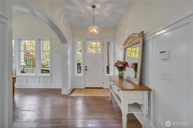 a view of a hallway with wooden floor and a dining room
