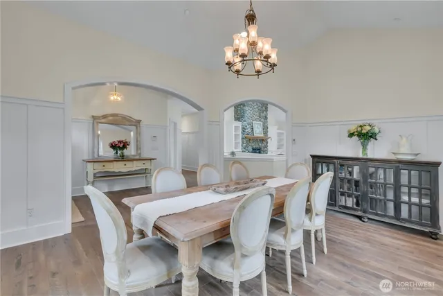 a view of a dining room with furniture a chandelier and wooden floor