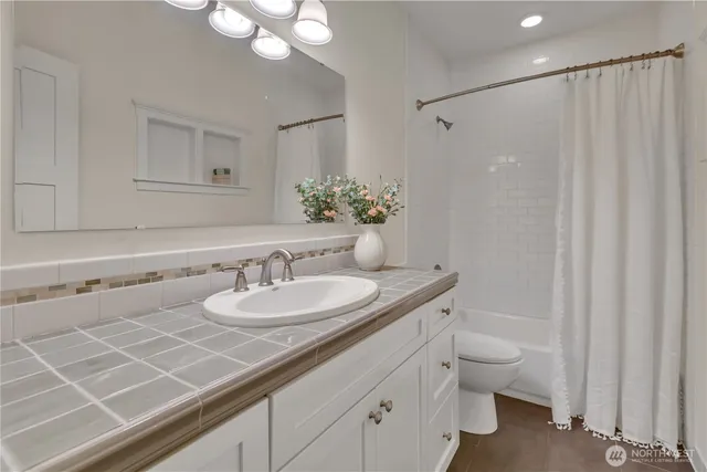 a bathroom with a granite countertop sink a toilet and a mirror