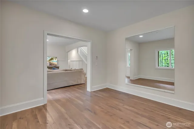 a view of empty room with wooden floor and window