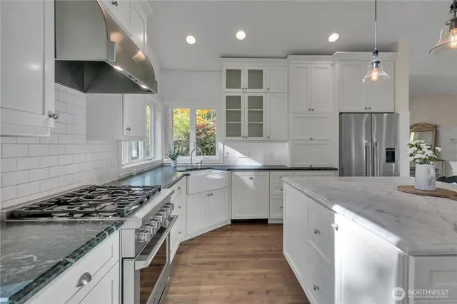 a kitchen with stainless steel appliances granite countertop a sink a stove and a refrigerator