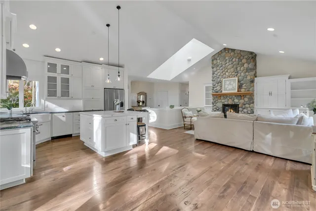 a large white kitchen with a large window and stainless steel appliances