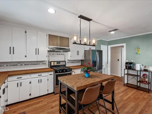 a kitchen with a table chairs microwave and cabinets