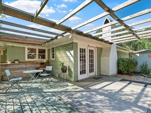 a view of a patio with table and chairs and wooden fence