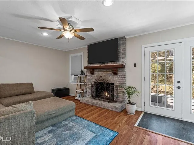 a living room with furniture a flat screen tv and a fireplace