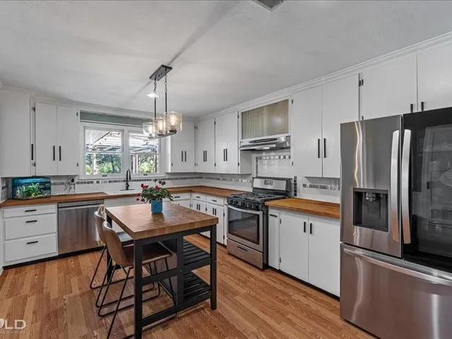 a kitchen with granite countertop a sink stove and refrigerator