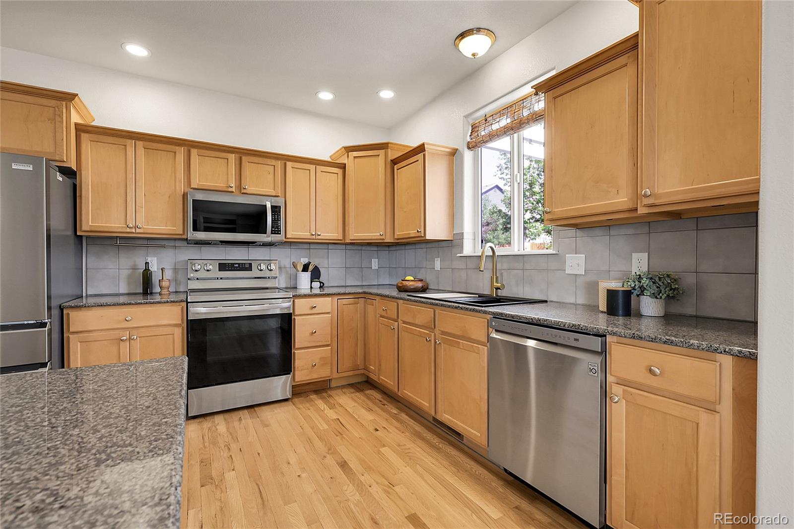 3406 Purcell Street Brighton, CO 80601 - Photo 13 of 50 a kitchen with stainless steel appliances granite countertop a stove sink microwave and cabinets