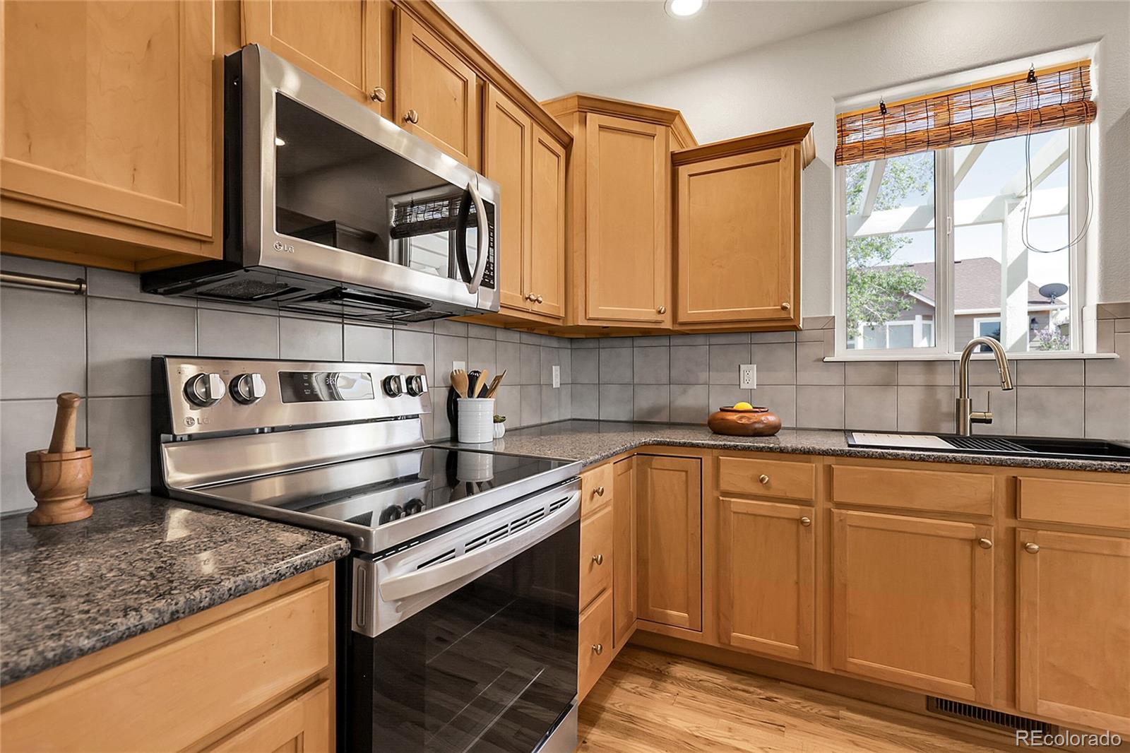 3406 Purcell Street Brighton, CO 80601 - Photo 14 of 50 a kitchen with kitchen island granite countertop a sink cabinets and stainless steel appliances