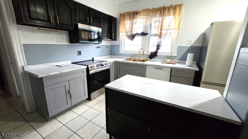 170 Spring Street Passaic, NJ 07055 - Photo 4 of 11 a kitchen with a sink a stove and refrigerator