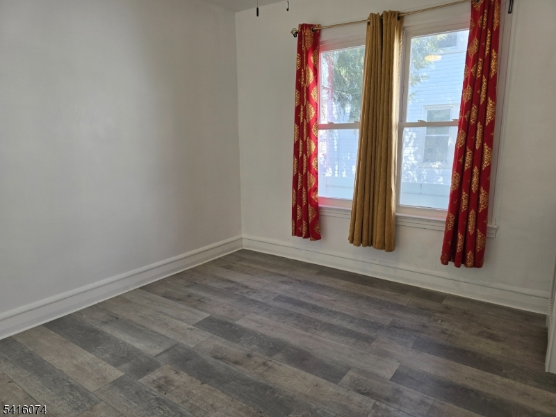 170 Spring Street Passaic, NJ 07055 - Photo 4 of 16 a view of a room with wooden floor and a window