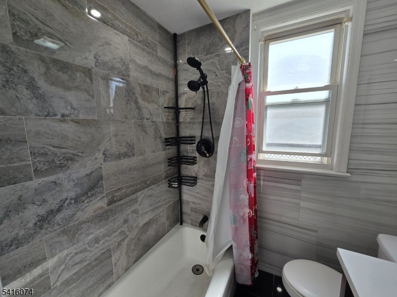 170 Spring Street Passaic, NJ 07055 - Photo 7 of 16 a bathroom with a bathtub and a shower