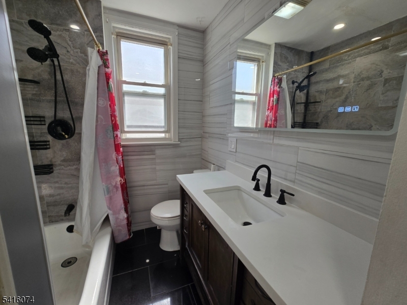 170 Spring Street Passaic, NJ 07055 - Photo 9 of 16 a bathroom with a sink a toilet a mirror and shower