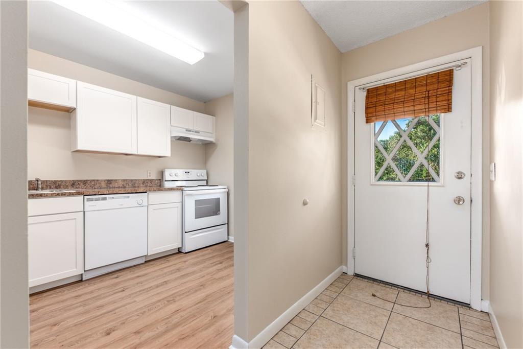 333 Southeast Martin Avenue, Unit 57 Stuart, FL 34996 - Photo 4 of 16 a kitchen with granite countertop white cabinets and white appliances