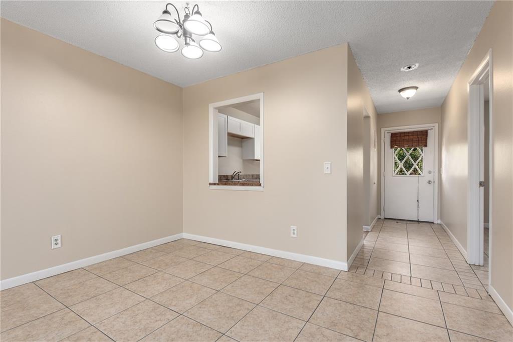 333 Southeast Martin Avenue, Unit 57 Stuart, FL 34996 - Photo 8 of 16 an empty room with a chandelier fan and glass door
