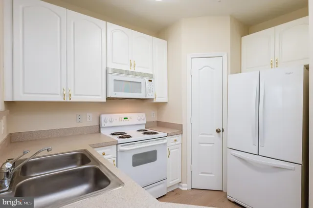 a view of a kitchen with wooden floor and a ceiling fan