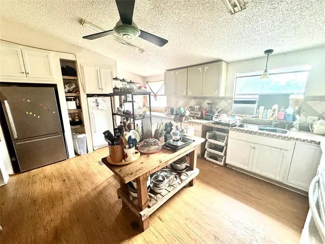 a kitchen with stainless steel appliances wooden floor dining table and chairs