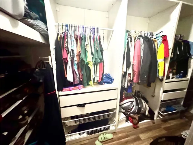 a view of walk in closet with clothes and shoes