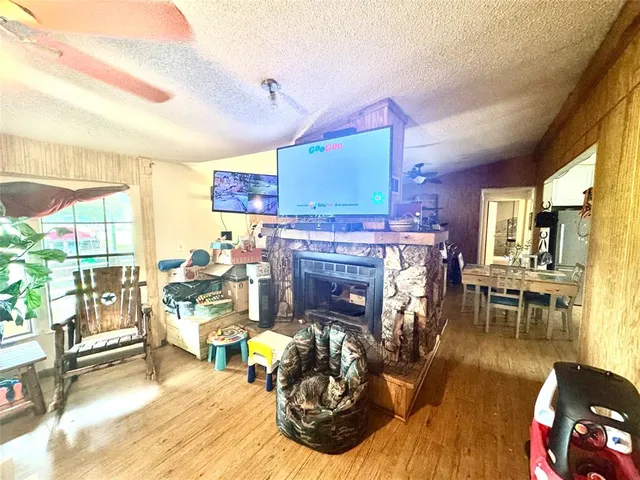 a living room with furniture a fireplace and large windows