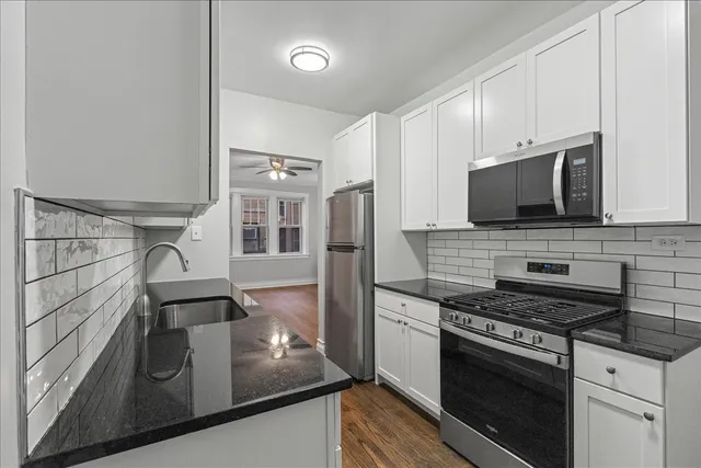 a kitchen with stainless steel appliances granite countertop a stove and a microwave