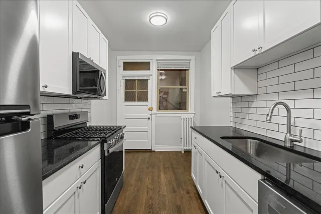 a kitchen with granite countertop a sink stainless steel appliances and cabinets