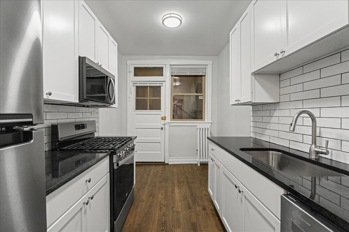 905 West Altgeld Street, Unit 1B Chicago, IL 60614 - Photo 3 of 11 a kitchen with granite countertop a sink stainless steel appliances and cabinets