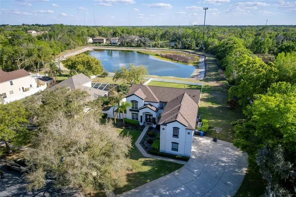 an aerial view of a house with a yard and lake view