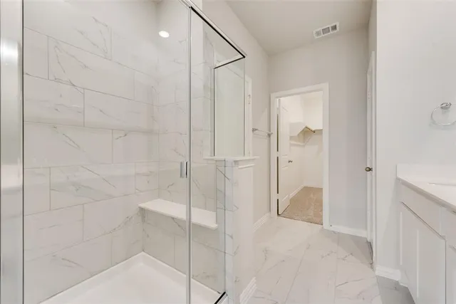a bathroom with a shower and a glass door