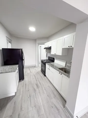 a kitchen with wooden floors and white appliances