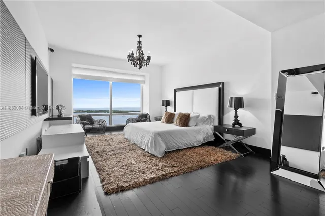 a spacious bedroom with a large bed and a chandelier