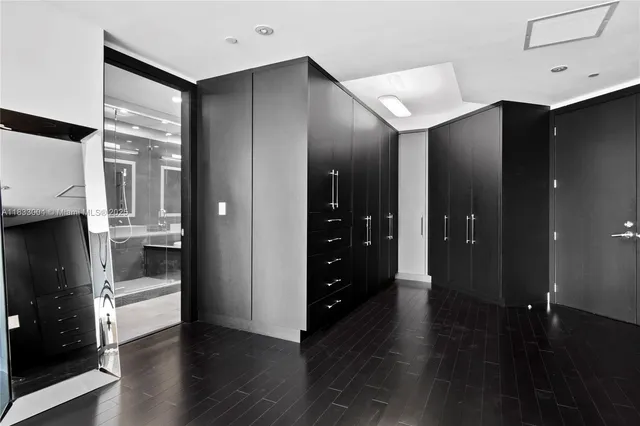 a hallway with wooden floor windows and a living room