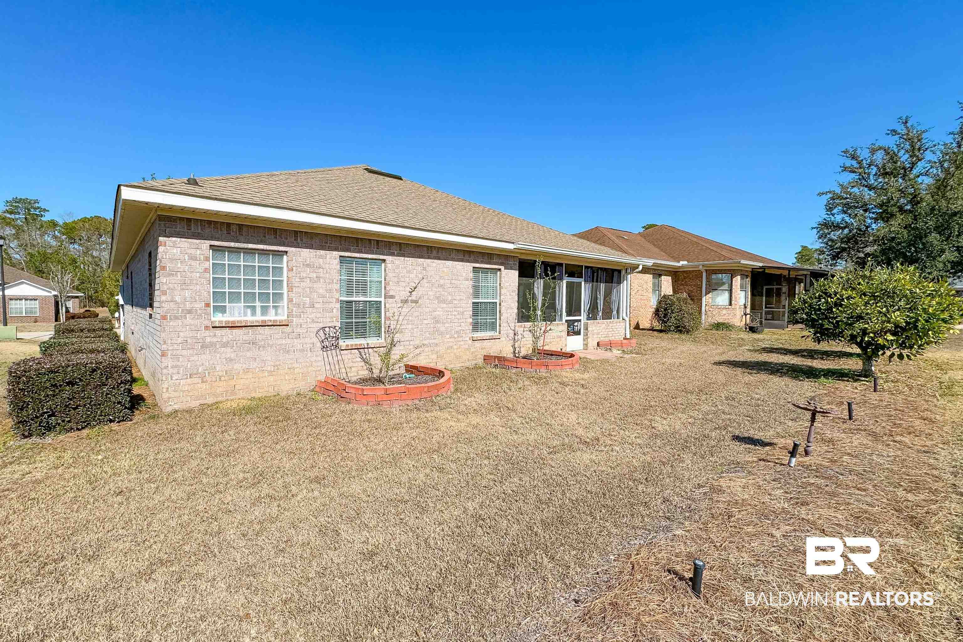 218 Hemingway Loop Foley, AL 36535 - Photo 28 of 39 Back of property with brick siding, a lawn, and roof with shingles