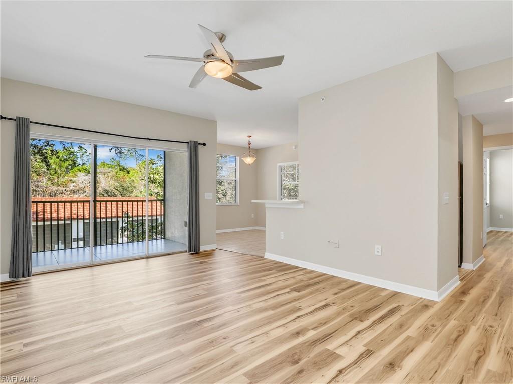 7935 Preserve Circle, Unit 423 Naples, FL 34119 - Photo 6 of 30 a view of an empty room with wooden floor and a window