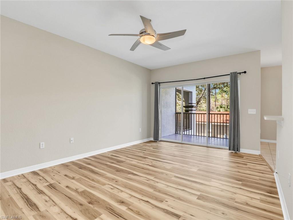 7935 Preserve Circle, Unit 423 Naples, FL 34119 - Photo 7 of 30 a view of a livingroom with wooden floor and a ceiling fan