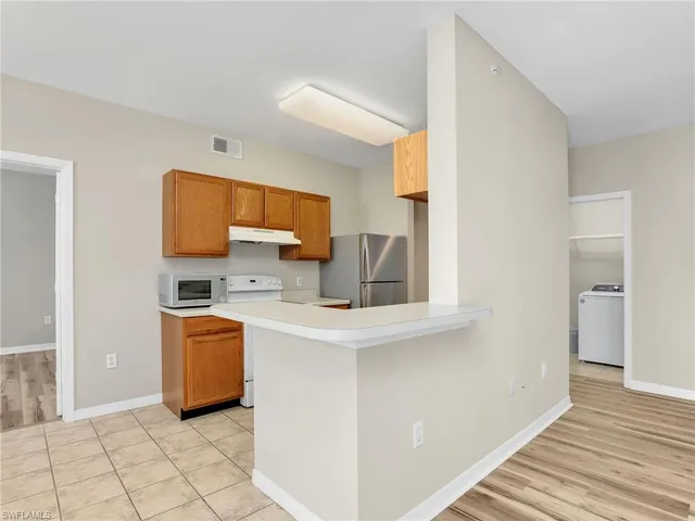 a kitchen with stainless steel appliances a microwave and a refrigerator