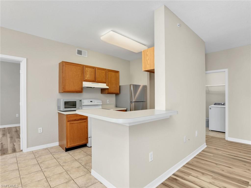 7935 Preserve Circle, Unit 423 Naples, FL 34119 - Photo 8 of 30 a kitchen with stainless steel appliances a microwave and a refrigerator