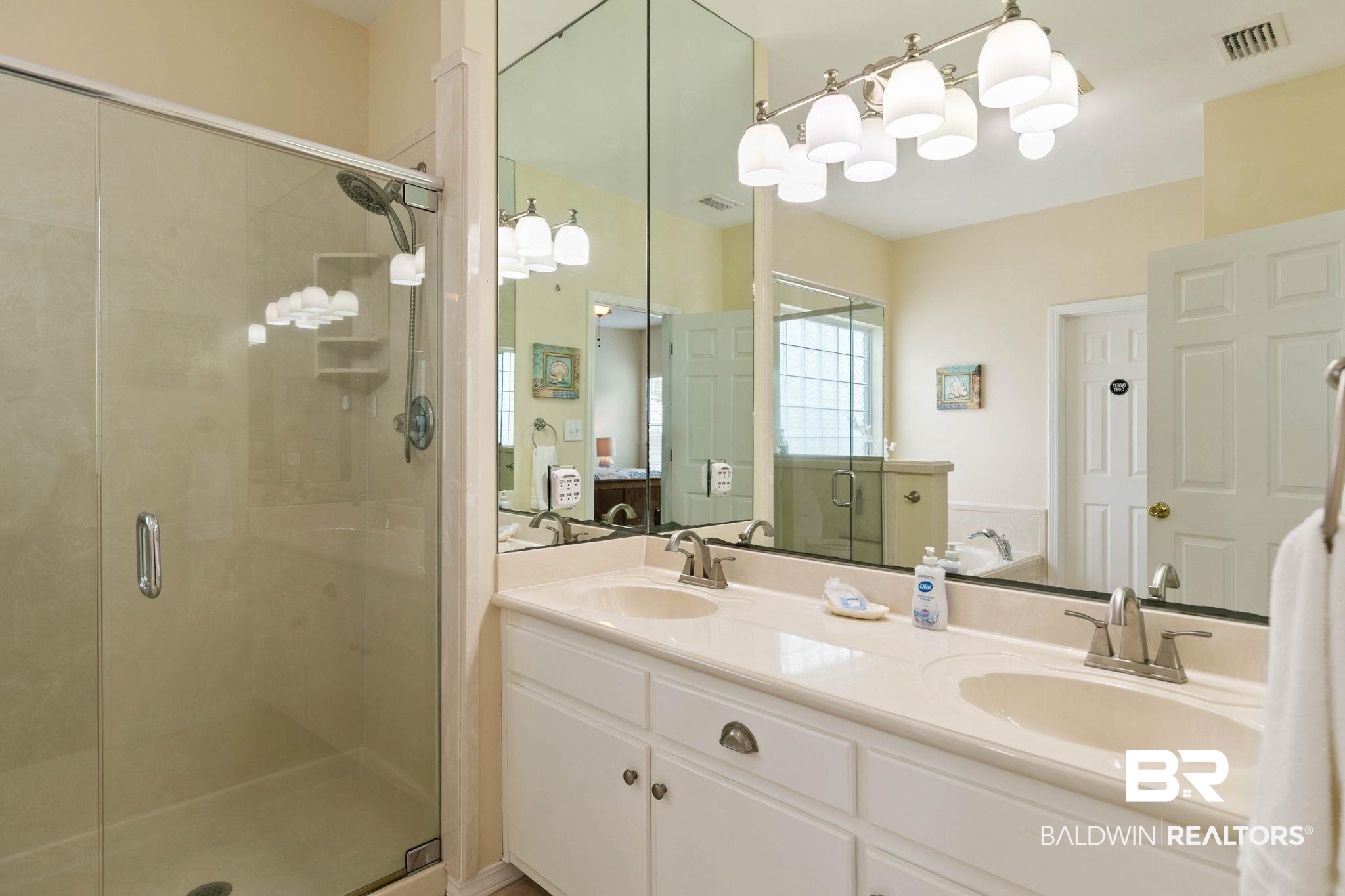 6802 Shore Drive Elberta, AL 36530 - Photo 19 of 34 Dual vanity with integrated sinks, brushed nickel fixtures, and a large wall-mounted mirror