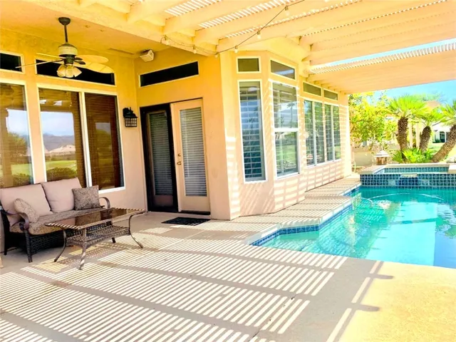 a view of a patio with couches chairs and floor to ceiling window